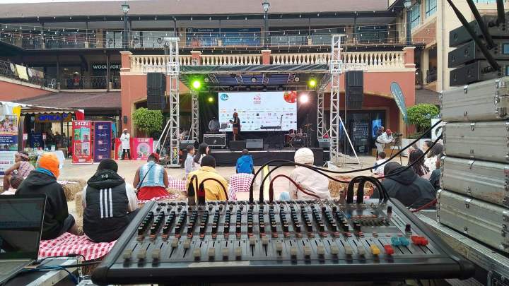 Professional stage setup with truss, rigging, speakers, lighting fixtures, clean event venue, realistic photo, wide stage, high detail